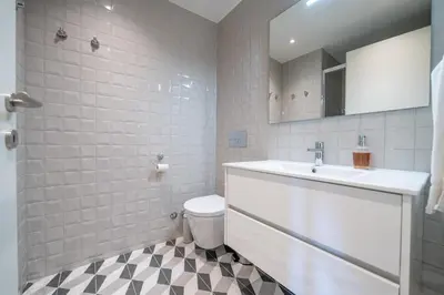 a white bathroom with a sink and a toilet at Trindade Duplex by Amber Star Rent in Porto