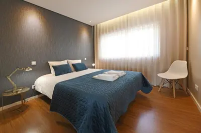 a bedroom with a large bed with a blue blanket at Music Apartment I in Porto