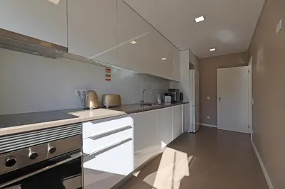 a kitchen with white cabinets and a counter top at Music Apartment I in Porto