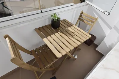 a wooden chair sitting on a porch with a plant at Music Apartment I in Porto