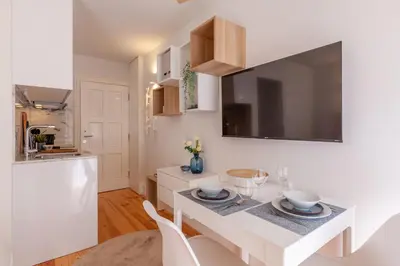 a white kitchen with a white table and chairs at D&S -JB Apartments in Porto