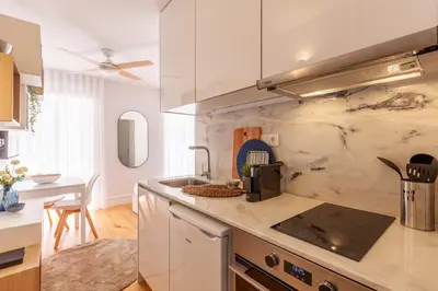 a kitchen with white cabinets and a counter top at D&S -JB Apartments in Porto