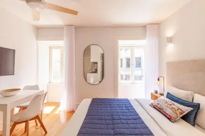 a bedroom with a bed and a table and a mirror at D&S -JB Apartments in Porto