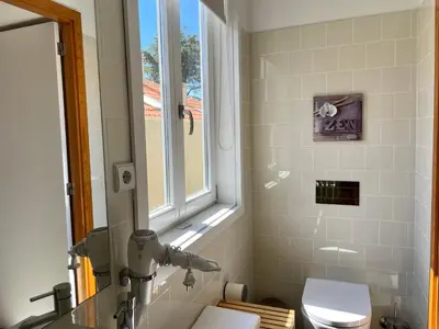 a bathroom with a toilet and a window and a sink at Santo António Elegant Flat in Porto