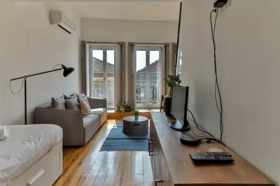 a living room with a couch and a television on a table at Loft Martires da Liberdade by Porto City Hosts in Porto