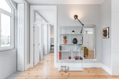 a white hallway with a mirror and a lamp at GuestReady - Colorful Apt near Agosto Station in Porto