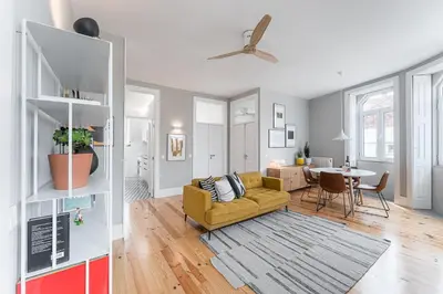 a living room with a yellow couch and a table at GuestReady - Colorful Apt near Agosto Station in Porto