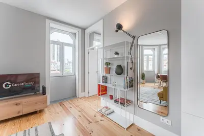a living room with a mirror and a tv at GuestReady - Colorful Apt near Agosto Station in Porto