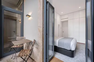 a bedroom with a bed and a table and a window at GuestReady - Casas de Mompilher in Porto