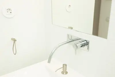 a bathroom sink with a faucet and a mirror at Apartamentos da Capela in Porto