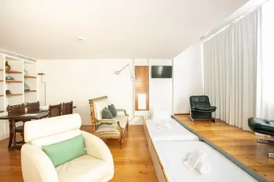 a living room with a white couch and chairs at Apartamentos da Capela in Porto