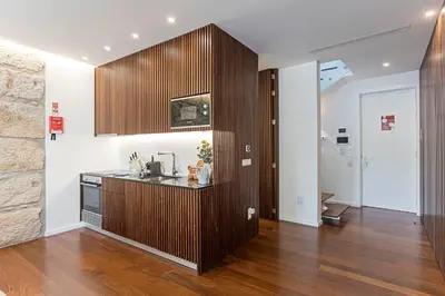 a kitchen with a wood paneled wall and a sink at Wonderful 2BR Duplex Near River by LovelyStay in Porto