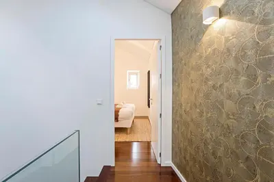 a hallway with a wall with a patterned wallpaper at Wonderful 2BR Duplex Near River by LovelyStay in Porto