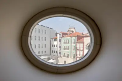 a round window with a view of a city at Palácio das Cardosas Studio by LovelyStay in Porto