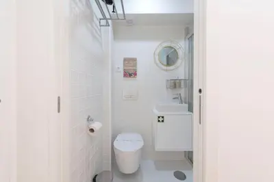 a white bathroom with a toilet and a sink at 31 de Janeiro Oporto House in Porto