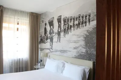 a bedroom with a painting of troops on the wall at Oca Ribeira do Porto Hotel in Porto