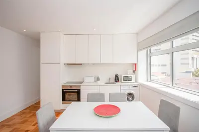 a white bedroom with a bed and a window at Liiiving in Porto - Sunny Santa Catarina in Porto