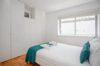 a white bedroom with a bed with towels on it at Liiiving in Porto - Sunny Santa Catarina in Porto