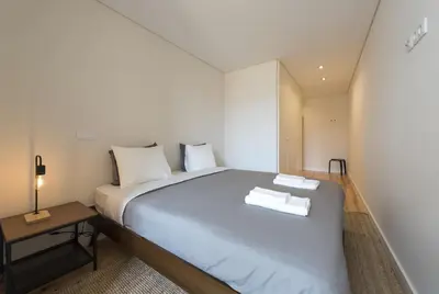 a bedroom with a bed with two towels on it at BmyGuest - São Vitor Balcony Apartment in Porto