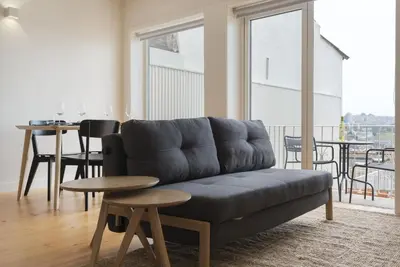 a living room with a couch and a table at BmyGuest - São Vitor Balcony Apartment in Porto