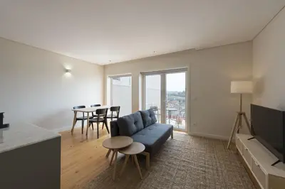 a living room with a couch and a table at BmyGuest - São Vitor Balcony Apartment in Porto