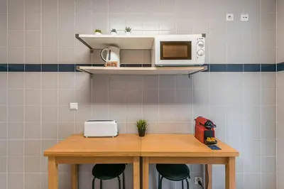 a kitchen with a wooden table with a microwave at Loulé 246 · 1 bedroom apartment · Parking in Porto