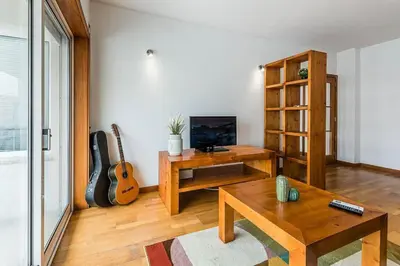 a living room with a table and a television and a guitar at Loulé 246 · 1 bedroom apartment · Parking in Porto