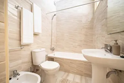 a bathroom with a toilet and a sink and a tub at Convenient 3-Bedroom Apartments next to Bom Sucesso in Porto