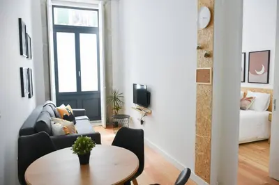 a living room with a table and a couch at Comfort next to main avenue and metro Trindade in Porto
