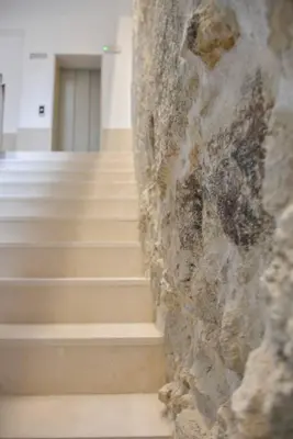 a set of stairs in a building with a stone wall at Comfort next to main avenue and metro Trindade in Porto