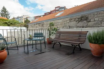 a wooden deck with a bench and a table and chairs at Oporto Trendy Formosa in Porto