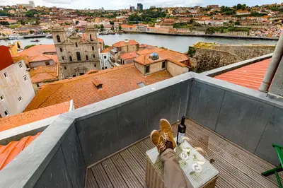 a person with their feet on the ledge of a building at NorteSoul City Center Amazing View in Porto