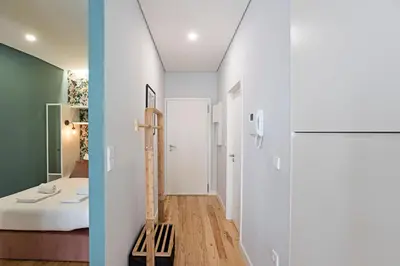 a small apartment with white walls and a room with a bed at Turquoise Central Flat w AC & Balcony by LovelyStay in Porto