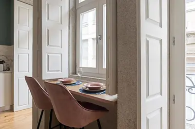 a dining room with a table and chairs and a window at Turquoise Central Flat w AC & Balcony by LovelyStay in Porto