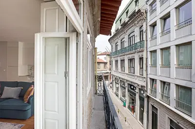 an open door to a balcony with a couch at Turquoise Central Flat w AC & Balcony by LovelyStay in Porto