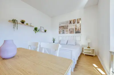 a white bedroom with a bed and a table at Travel and Live Faria Guimarães in Porto