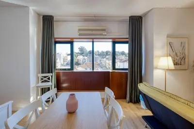a dining room with a table and chairs and a window at Travel and Live Faria Guimarães in Porto