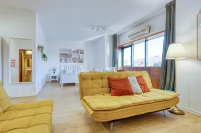 a living room with a yellow couch and a table at Travel and Live Faria Guimarães in Porto