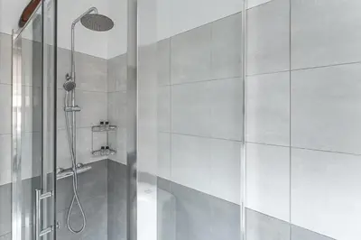 a bathroom with a shower with a glass door at GuestReady - Modern Duplex, Neo-Classical Building in Porto