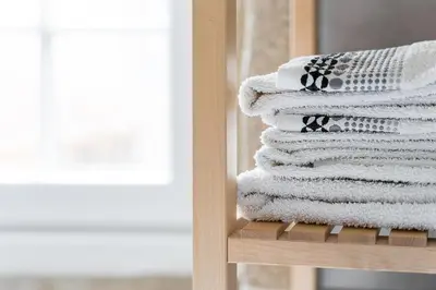 a stack of towels sitting on a shelf next to a window at GuestReady - Modern Duplex, Neo-Classical Building in Porto