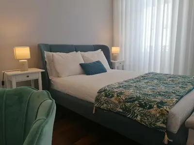 a bedroom with a bed and two tables and a window at Cool Suites in Porto