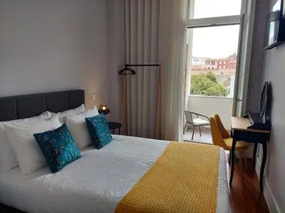 a bedroom with a bed with blue pillows and a window at Cool Suites in Porto