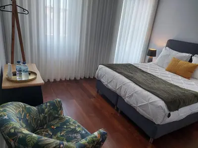 a bedroom with a bed and a chair in it at Cool Suites in Porto