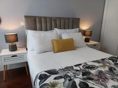 a bedroom with a large bed with two night stands at Cool Suites in Porto