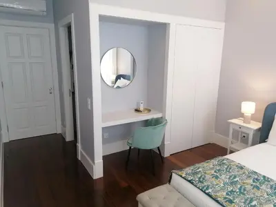 a bedroom with a bed and a mirror and a chair at Cool Suites in Porto