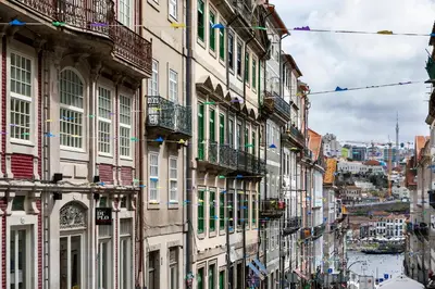 a group of buildings on a street with a river at ICON Duplo Ribeira in Porto