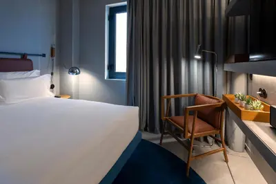 a hotel room with a bed and a chair at ICON Duplo Ribeira in Porto
