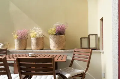 a table and chairs with flowers on a shelf at Tripas-Coração, Almada Charming City Center in Porto