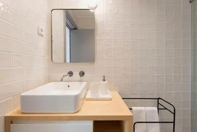 a bathroom with a white sink and a mirror at Tripas-Coração, Almada Charming City Center in Porto