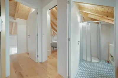 a bathroom with a shower in a room with wooden ceilings at Downtown Clerigos Duplex With River View by Vacationy in Porto